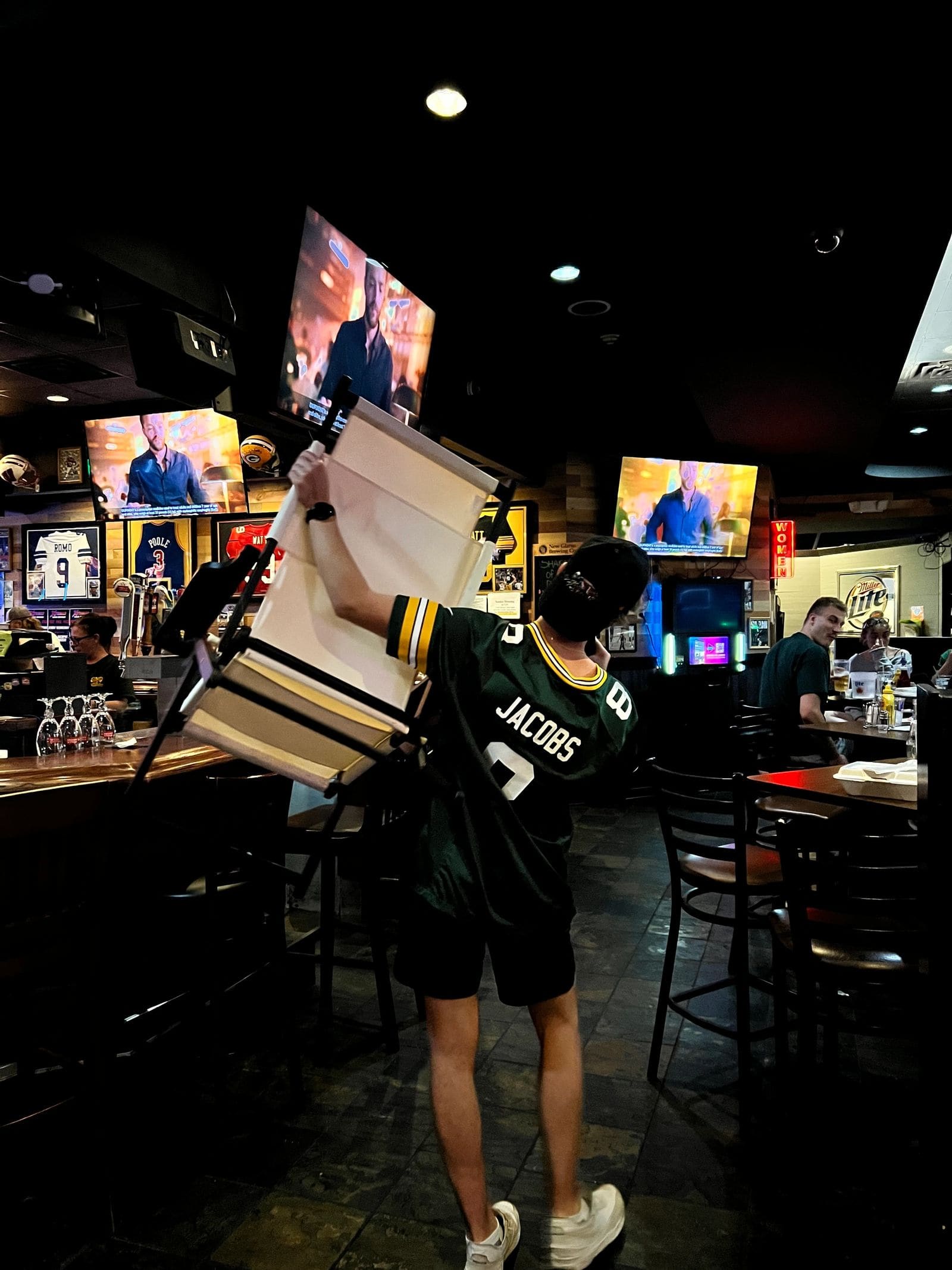 A server in a Packers jersey working the floor on game day
